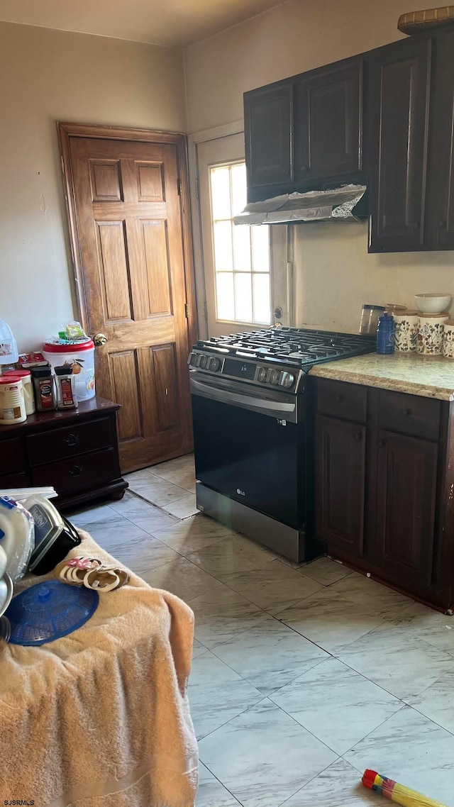 kitchen featuring dark brown cabinets and gas stove