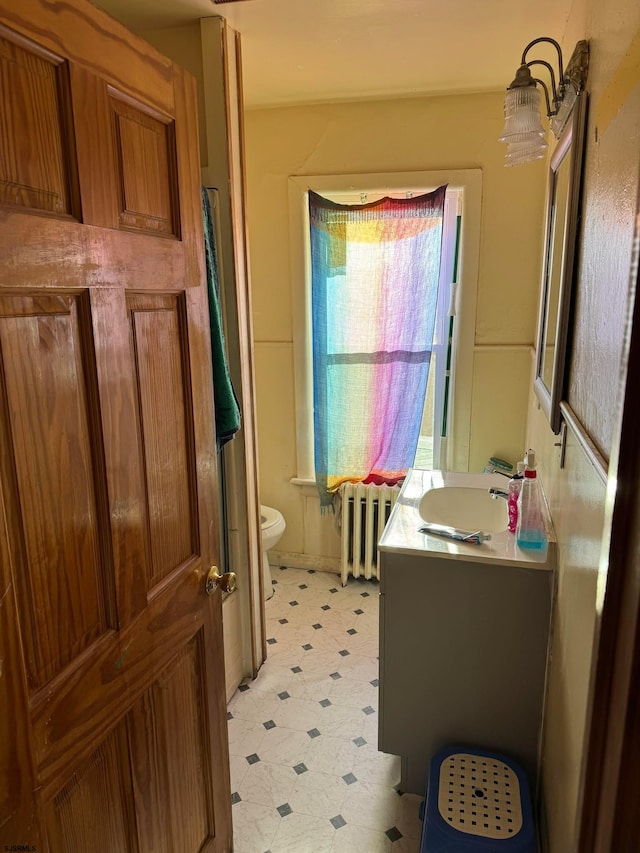 bathroom featuring vanity, toilet, and radiator