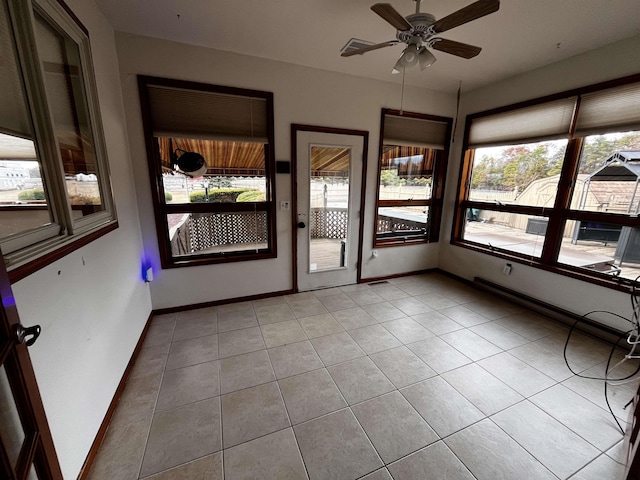 unfurnished sunroom with ceiling fan