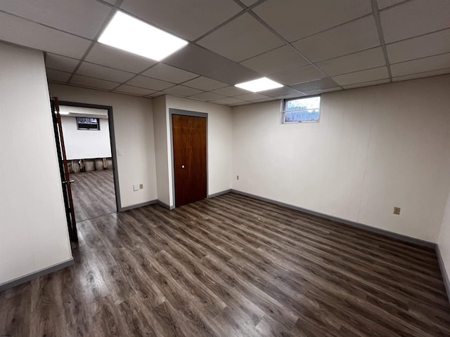 spare room featuring a drop ceiling and dark hardwood / wood-style flooring