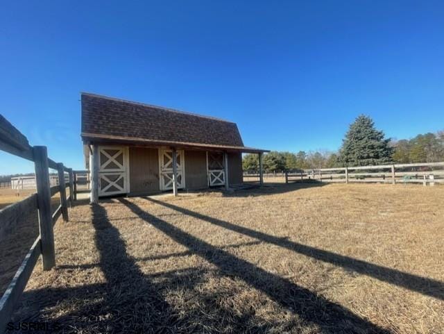 view of horse barn featuring a rural view