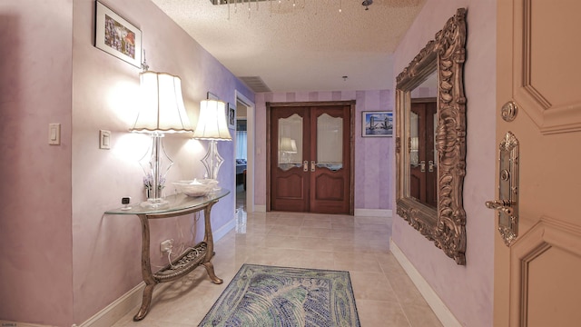 corridor featuring a textured ceiling and light tile patterned flooring