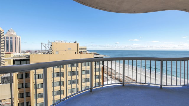 balcony featuring a water view and a beach view