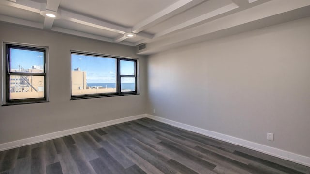 spare room with beamed ceiling, dark wood-type flooring, and coffered ceiling