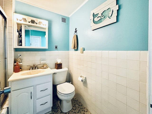 bathroom featuring crown molding, vanity, and tile walls