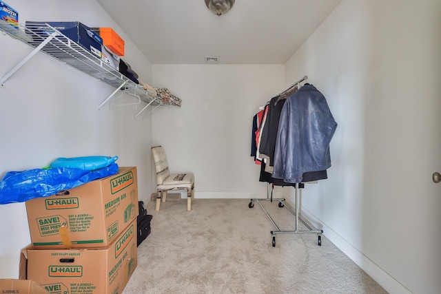 walk in closet featuring light carpet