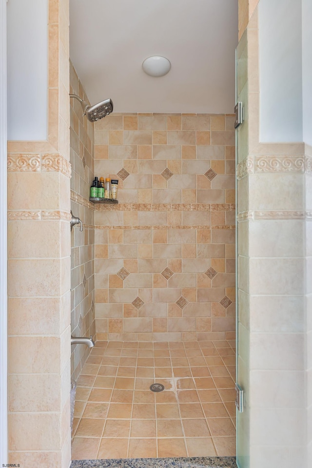 bathroom featuring a shower with door and tile walls