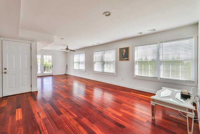 unfurnished living room with ceiling fan and dark hardwood / wood-style flooring