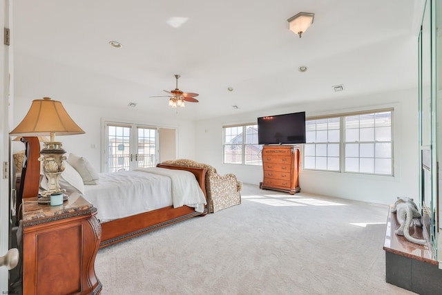 bedroom with ceiling fan, light carpet, and french doors