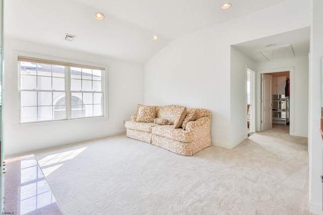 living area featuring light carpet and vaulted ceiling