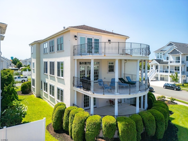 back of property with a balcony and a patio