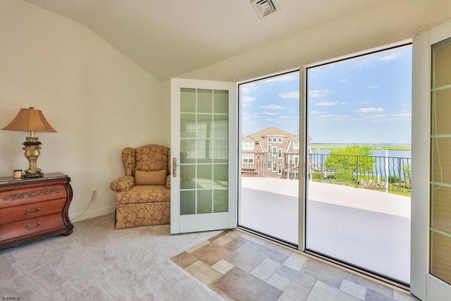 doorway featuring light colored carpet, a water view, and vaulted ceiling