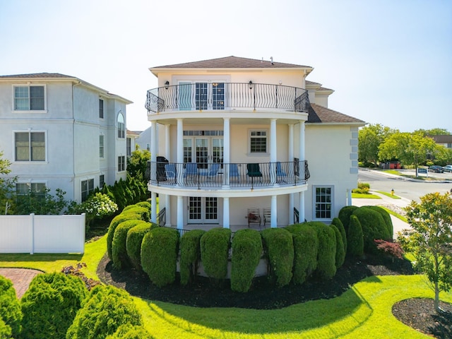 back of property featuring a yard and a balcony