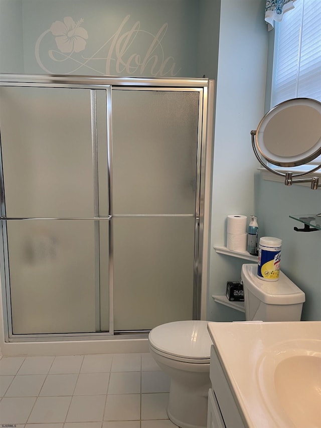 bathroom with tile patterned flooring, vanity, a shower with door, and toilet