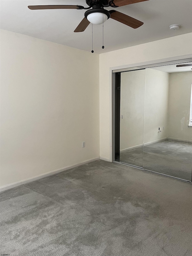 unfurnished bedroom with ceiling fan and a closet