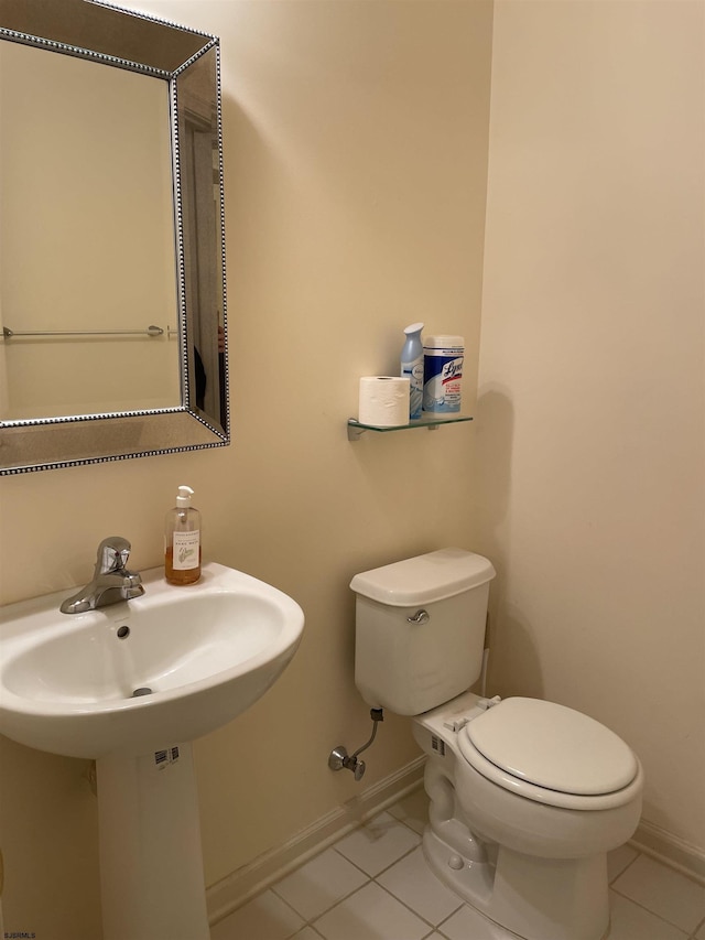 bathroom featuring toilet, tile patterned floors, and sink