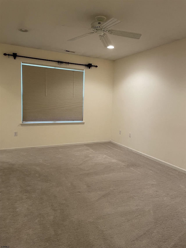 carpeted spare room with ceiling fan