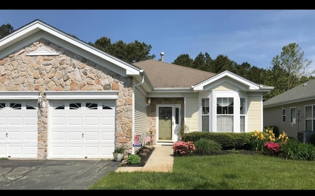 ranch-style home with a front lawn and a garage