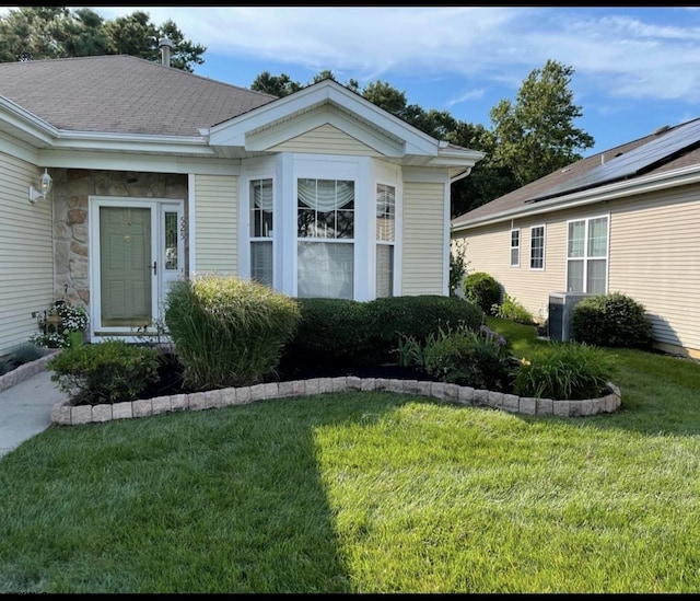 view of exterior entry featuring solar panels and a lawn