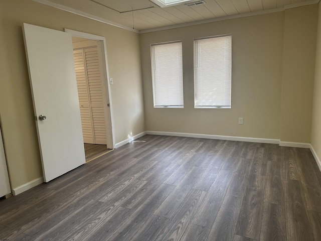 unfurnished bedroom featuring crown molding, a closet, and dark wood-type flooring