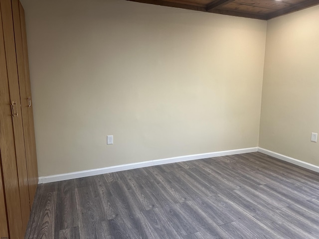 empty room featuring dark wood-type flooring and wood ceiling