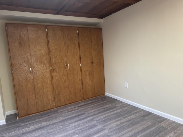 unfurnished bedroom featuring dark hardwood / wood-style flooring and wood ceiling