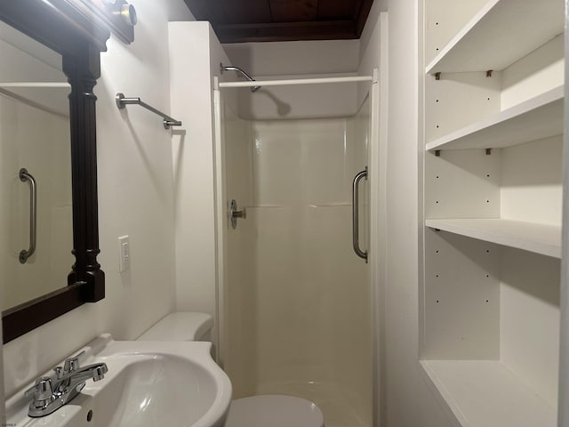 bathroom with toilet, sink, and walk in shower