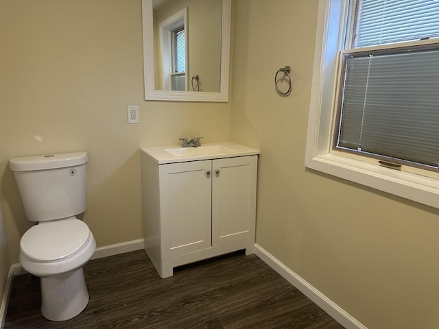 bathroom featuring toilet, vanity, and hardwood / wood-style flooring