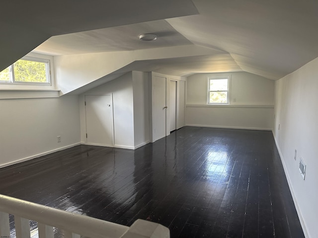 bonus room with dark hardwood / wood-style flooring and lofted ceiling