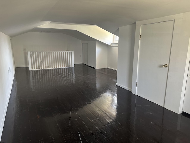 additional living space featuring dark hardwood / wood-style floors and vaulted ceiling