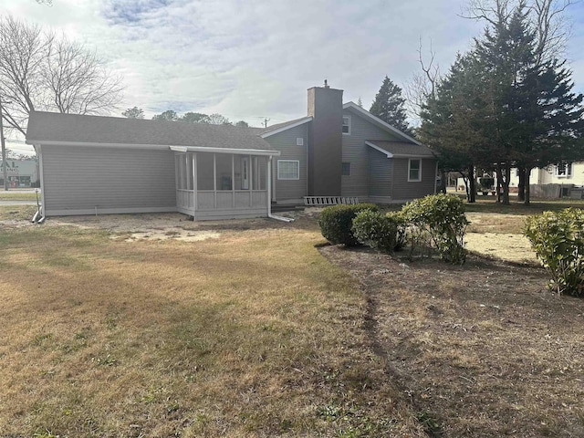 back of property featuring a sunroom and a yard