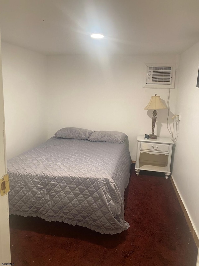 bedroom with an AC wall unit and carpet flooring