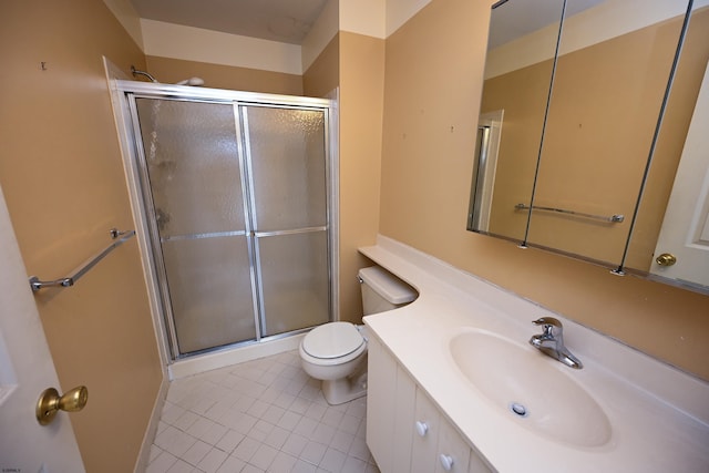 bathroom with toilet, vanity, tile patterned floors, and a shower with shower door