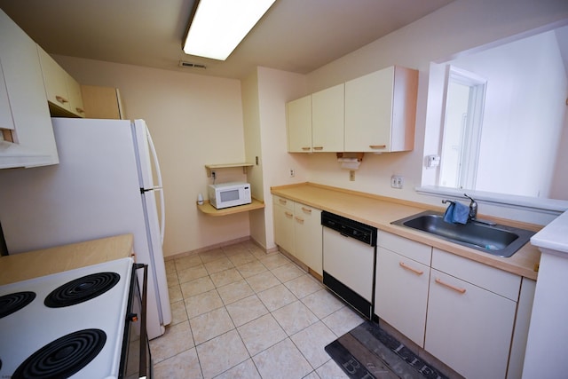 kitchen featuring white cabinets, white appliances, sink, and light tile patterned floors