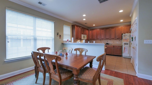 dining room featuring light hardwood / wood-style floors and ornamental molding