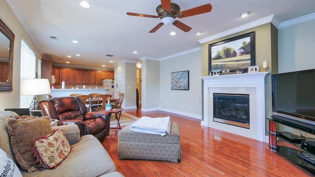 living room with ceiling fan, light hardwood / wood-style floors, and ornamental molding