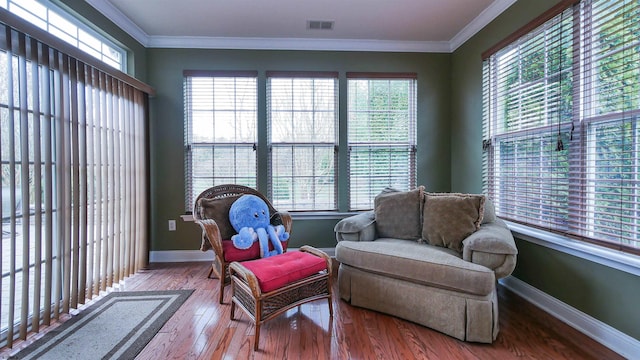 living area with crown molding and hardwood / wood-style floors