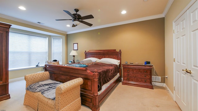 carpeted bedroom with a closet, ceiling fan, and crown molding