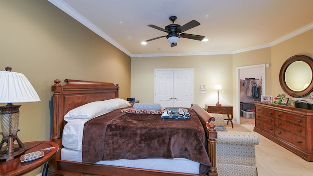 carpeted bedroom featuring ceiling fan, a closet, a spacious closet, and ornamental molding