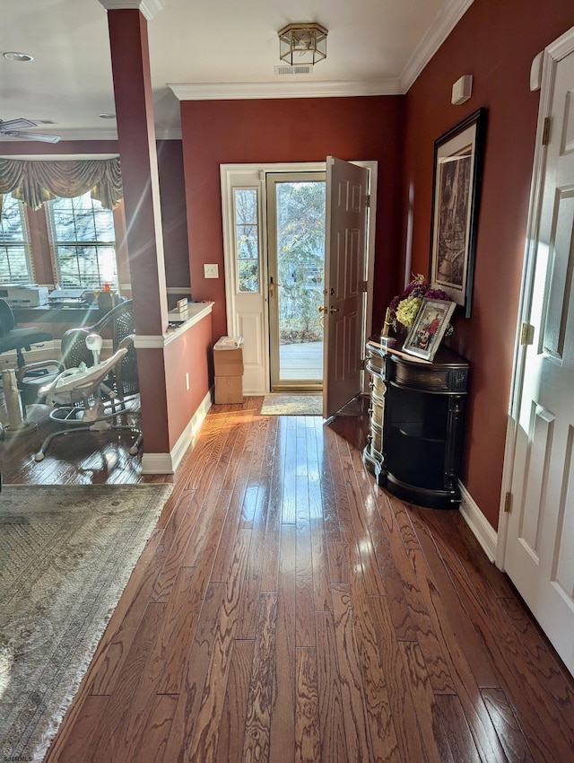 foyer with crown molding, plenty of natural light, and hardwood / wood-style flooring