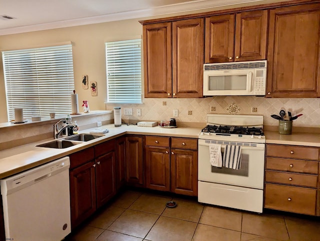 kitchen featuring a wealth of natural light, sink, light tile patterned flooring, and white appliances