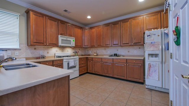 kitchen with white appliances, sink, light tile patterned floors, ornamental molding, and tasteful backsplash