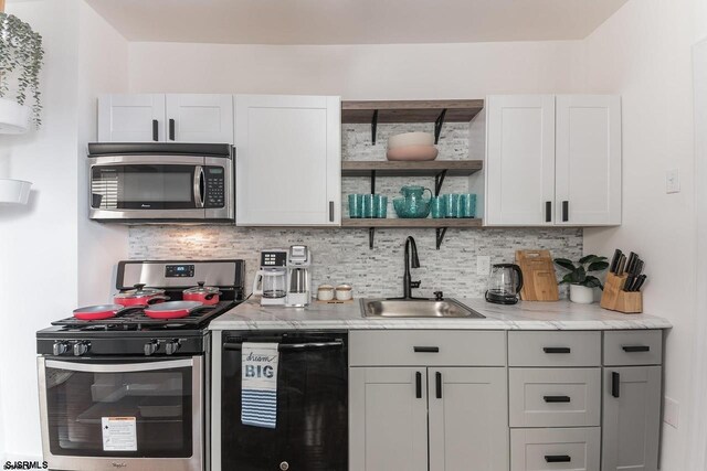 kitchen featuring backsplash, white cabinetry, sink, and stainless steel appliances