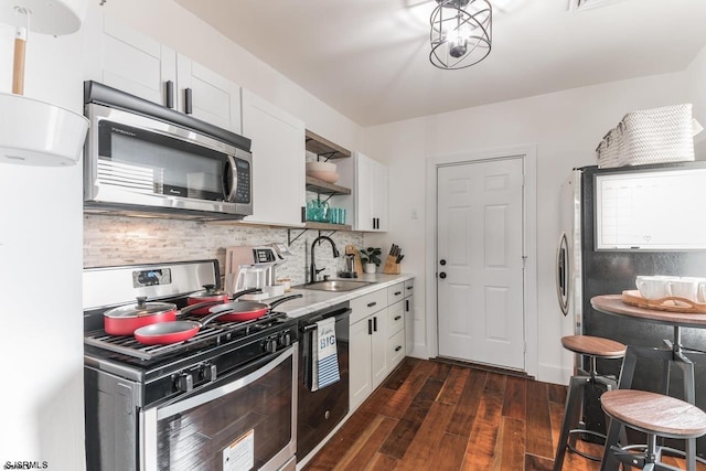 kitchen featuring dark hardwood / wood-style flooring, tasteful backsplash, stainless steel appliances, sink, and white cabinets