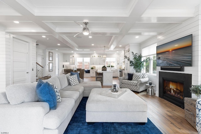 living room with ceiling fan, coffered ceiling, beamed ceiling, and dark hardwood / wood-style floors