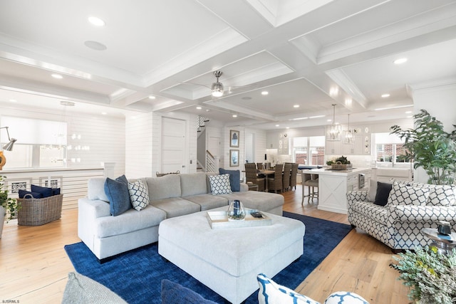 living room with coffered ceiling, beam ceiling, and light hardwood / wood-style flooring