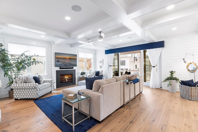 living room with ceiling fan, coffered ceiling, beamed ceiling, hardwood / wood-style floors, and wooden walls