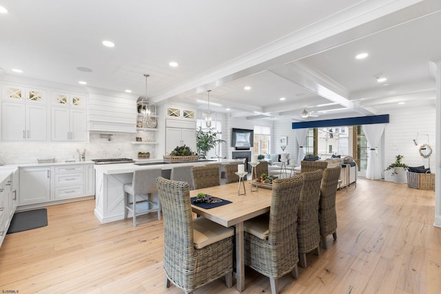 dining room featuring light hardwood / wood-style flooring and beamed ceiling