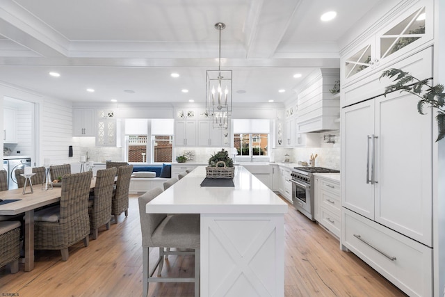 kitchen featuring white cabinets, plenty of natural light, and high end stove