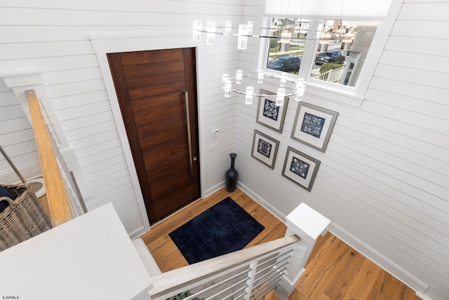 entryway with wooden walls and wood-type flooring